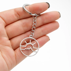 Macro shot of silver stainless steel keychain featuring sun and mountain cutout
