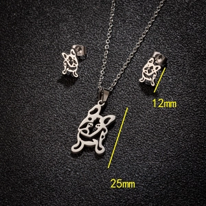 Stainless steel pug necklace and stud earrings jewelry set on black textured background