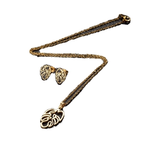Golden stainless steel jewelry set featuring monstera leaf pendant necklace and earrings