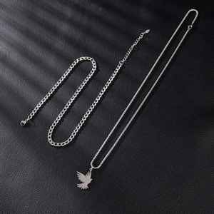 Detailed view of silver stainless steel bird pendant necklace and cuban link bracelet set