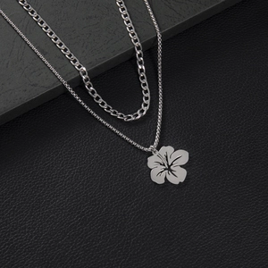 Detail of layered stainless steel flower pendant with Cuban link and box chain