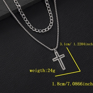 Close-up of gothic silver double cross pendant with cuban chain on black leather