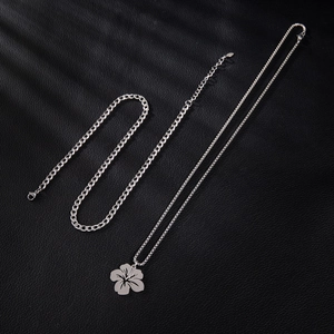 Silver stainless steel floral pendant necklace with cuban chain on black leather background