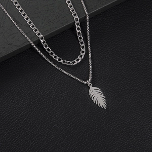 Double-layered silver feather pendant necklace featuring Cuban and box chain link styles