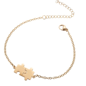 Détail d'un bracelet puzzle doré ajustable avec fermoir mousqueton et chaîne fine