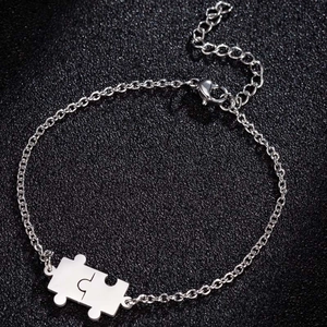 Bracelet puzzle ajustable en acier inoxydable avec chaîne fine sur fond texturé noir