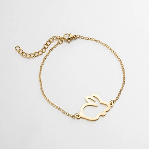 Detail of minimalist golden stainless steel bracelet featuring a hollow rabbit head pendant