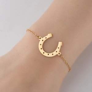 Minimalist 18K gold stainless steel horseshoe pendant bracelet shown on a female wrist