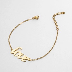 Detail of a gold-plated LOVE charm bracelet with lobster clasp and adjustable extension chain