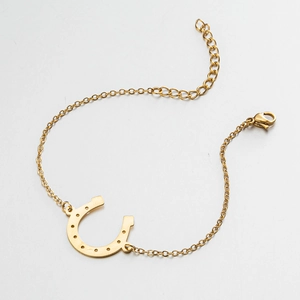 Detail showing gold U-shaped horseshoe pendant and adjustable lobster clasp chain
