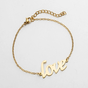 Close-up of golden love script pendant bracelet with adjustable lobster clasp chain