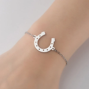 Elegant silver stainless steel horseshoe pendant bracelet shown on a woman wrist