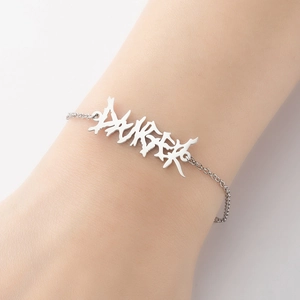 Macro detail of gothic stainless steel bracelet featuring an irregular DANGER pendant