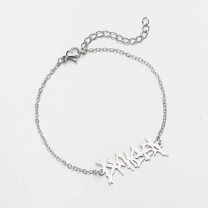 Detail of silver chain bracelet featuring a graffiti style letter plate with lobster clasp