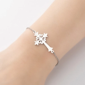 Silver cross pendant bracelet with intricate hollow pattern shown on a wrist