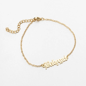 Makro-Detail des goldenen Edelstahl-Babygirl-Anhängers mit Karabinerverschluss