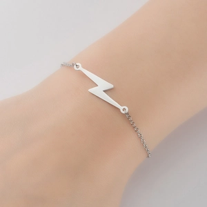 Detailed view of a minimalist silver lightning bolt charm on a fine stainless steel chain