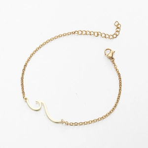 Detail eines minimalistischen Gold-Wellenarmbands mit Karabinerverschluss und Kette