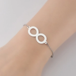 Détail d'un bracelet infini argenté au poignet avec une finition polie élégante
