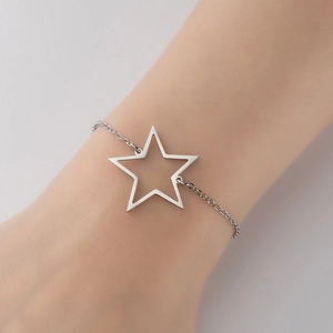 Detailed close-up of a hollow star pendant on a polished steel chain worn on a wrist