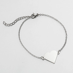 Macro detail of silver stainless steel chain bracelet with a polished heart pendant