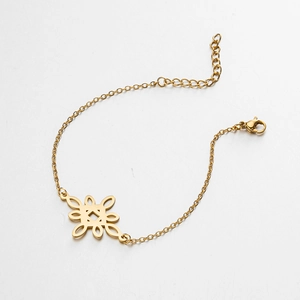 Detail of a gold stainless steel bracelet featuring a hollow geometric knot charm