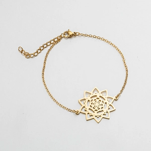 Detailed macro view of a gold-plated mandala pendant and fine chain link with lobster clasp