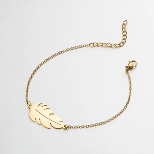 Detailed macro view of a golden minimalist chain featuring a delicate leaf pendant detail