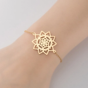 Close-up of a minimalist gold mandala flower pendant bracelet worn on a woman's wrist