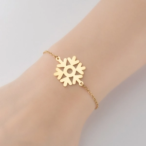 Elegant gold snowflake pendant bracelet on woman's wrist for winter style accessories