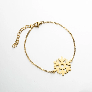 Detailed view of a gold snowflake pendant bracelet with lobster clasp and extension chain