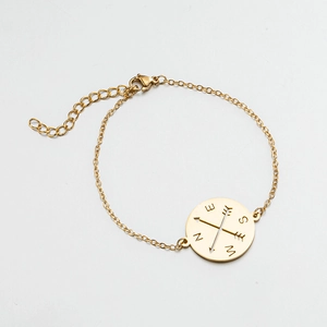 Detail of gold compass pendant on chain with lobster clasp and adjustable link