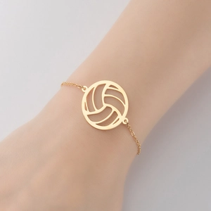 Détail d'un pendentif de volleyball en acier inoxydable doré sur une chaîne minimaliste