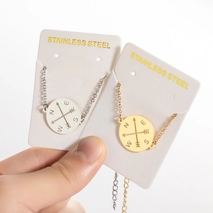 Stainless steel compass pendant bracelets with cutout arrow designs in gold and silver