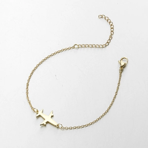 Detail of a gold stainless steel airplane pendant bracelet with a polished finish