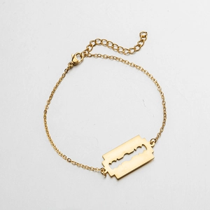 Detail of gold razor blade pendant on a fine chain bracelet with lobster clasp