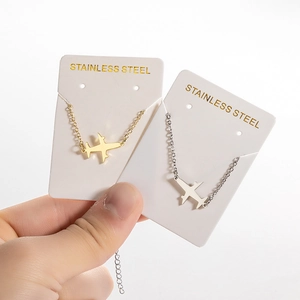 Minimalist stainless steel airplane charm bracelets in gold and silver finish on display cards