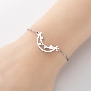 Minimalist silver moon and stars pendant bracelet shown on a woman wrist