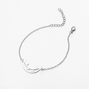 Detailed view of silver celestial bracelet featuring a hollow crescent moon and star pendant