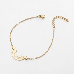Detail of golden moon and star pendant bracelet with lobster clasp and adjustable chain