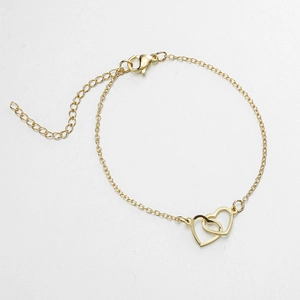 Dettaglio di un bracciale dorato a doppio cuore con catena regolabile e chiusura a moschettone