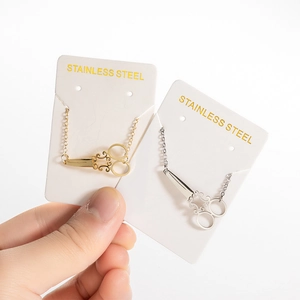 Unique scissors shape bracelet in gold and silver finish on display cards