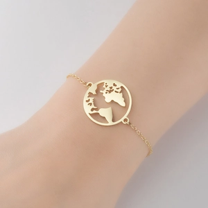 Minimalist gold world map cutout pendant bracelet on wrist with dainty chain
