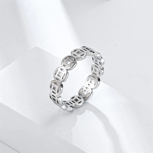 Detail of silver vintage coin ring featuring cut-out ancient square hole design patterns