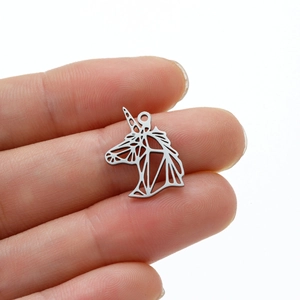 Detailed close-up showing a silver unicorn pendant with geometric hollow-out design