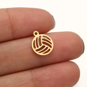 Detailed macro of a 18K gold plated volleyball pendant showing hollowed out stitch design
