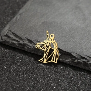 Macro view of a gold-colored geometric hollow unicorn pendant on dark stone surface