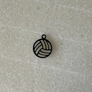 Close-up of black 18K gold-plated volleyball charm with silver lines for DIY jewelry