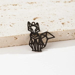 Macro view of matte black hollow origami fox pendant on light stone texture