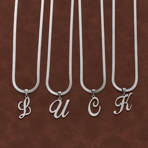 Vue détaillée des lettres argentées LUCK sur une chaîne serpent plate en acier inoxydable